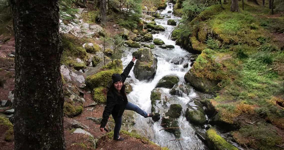 Participante explorando un bosque junto a un río